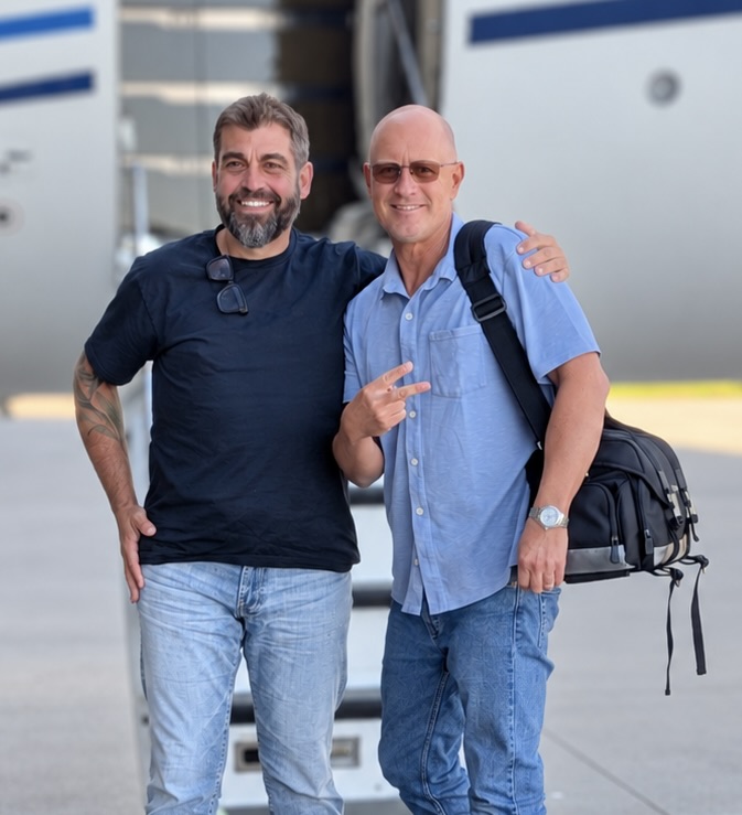 Two smiling reptile enthusiasts standing together outdoors