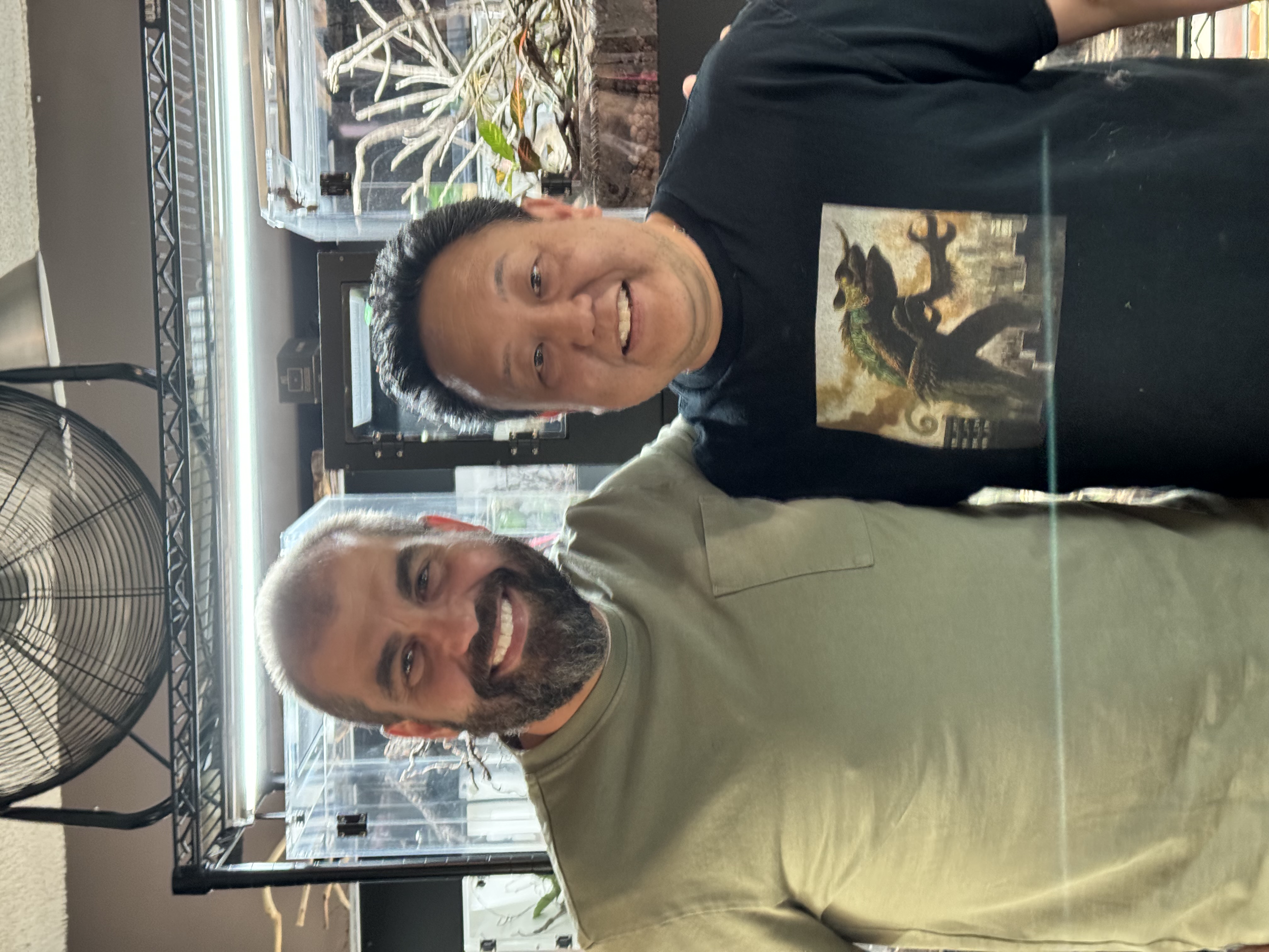 Two people standing together in front of reptile enclosures
